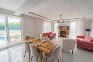 a living room with a wooden table and chairs at Villa Horizon in Ortaca