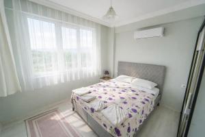 a bedroom with a bed and two windows at Villa Horizon in Ortaca