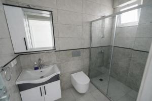 a bathroom with a shower and a toilet and a sink at Villa Horizon in Ortaca +6 photos