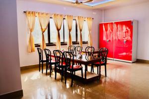 a dining room with a table and chairs in a museum at Sky View Guest House in Shānti Niketan