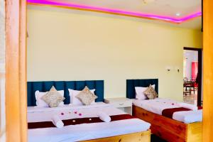 a bedroom with two beds and a mirror at Sky View Guest House in Shānti Niketan +142 photos