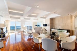 a dining room with a glass table and white chairs at Cascais Lux - New Apartment in Parede