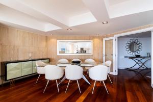 a dining room with a table and white chairs at Cascais Lux - New Apartment in Parede