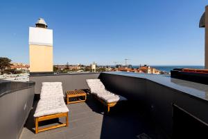 a lighthouse on a balcony with two chairs and a lighthouse at Cascais Lux - New Apartment in Parede +22 photos