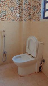 a bathroom with a toilet with the seat up at The Moksha Residency in Prayagraj