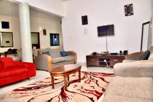 a living room with a red couch and a red table at La belle vie in Rufisque