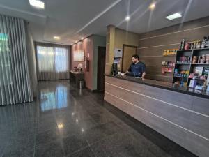 a man standing at a counter in a restaurant at Hotel do Porto in Porto Velho