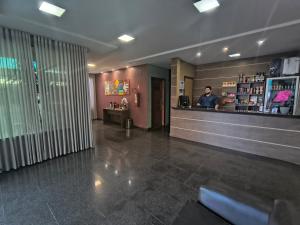 a lobby with a pharmacistacist at a counter in a pharmacy at Hotel do Porto in Porto Velho