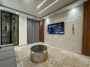 a living room with a couch and a tv on a wall at Cabilyt Cairo Luxiury Apartment in Obour