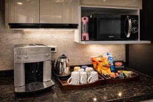a kitchen counter with a coffee maker and a microwave at Cabilyt Cairo Luxiury Apartment in Obour