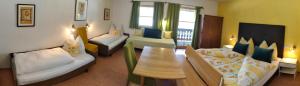 a room with two beds and a table and a couch at Berghotel Hinterduxerhof in Sparchen