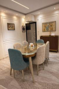 a dining room with a glass table and chairs at Cabilyt Cairo Luxiury Apartment in Obour +23 photos
