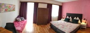 a bedroom with a bed and a pink wall at Berghotel Hinterduxerhof in Sparchen +9 photos