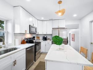 a kitchen with white cabinets and a white counter top at Hot Tub 5 Mins from Cedar Point Modern Updates in Sandusky