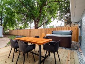 a patio with a wooden table and chairs and a grill at Hot Tub 5 Mins from Cedar Point Modern Updates in Sandusky