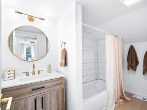 a bathroom with a tub and a sink and a mirror at Hot Tub 5 Mins from Cedar Point Modern Updates in Sandusky