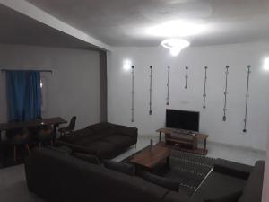 a living room with a couch and a tv at KEUR MAMY DOUSSOU à Ndangane campement in Ndangane +1 photo