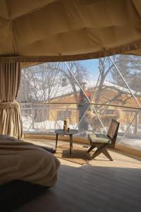a room with a window with a chair and a table at Anima Resort Aghveran - Forest Retreat in Aghveran