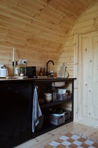 a kitchen with a black counter and a wooden ceiling at Glamping Pod in de natuur Eigen badkamer in Oudehornstercompagnie