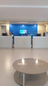 a lobby with a table in the middle of a room at Flat colado a praia de Boa Viagem in Recife