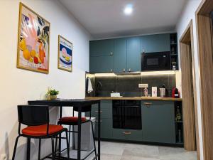 a kitchen with green cabinets and two bar stools at Apartman Mali Muk 2, self check in in Karlovac