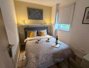 a bedroom with a bed with a bottle of wine on it at Apartman Mali Muk 2, self check in in Karlovac