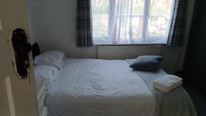 a small bed in a bedroom with a window at Zoran home 3 in Leicester