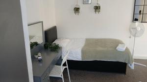 a bedroom with a bed and a desk with a mirror at Zoran home 3 in Leicester