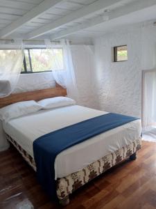 a bedroom with a bed with a blue and white blanket at Amplio Apartamento en San Cristóbal con AC, Casa Oasis Galápagos in Puerto Baquerizo Moreno