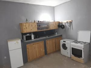 a small kitchen with a stove and a microwave at KEUR MAMY DOUSSOU à Ndangane campement in Ndangane