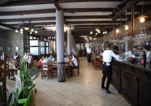 a man standing at a bar in a restaurant at Resort Nord Park in Fushë-Krujë