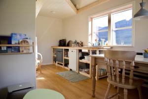 a kitchen with a wooden table and a dining room at FjordNest Cabin in Hvannasund
