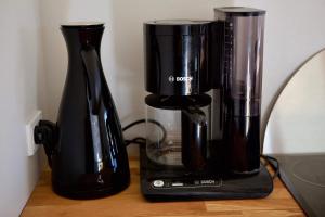 a black coffee maker sitting on a wooden table at FjordNest Cabin in Hvannasund