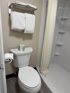 a bathroom with a toilet and a shower and towels at Studios 4 Less Chesapeake in Chesapeake +3 photos