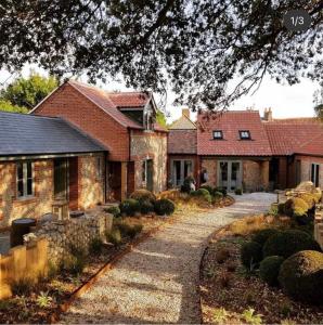 a large brick house with a walkway in front of it at NoTwenty9 Bar and Restaurant in Burnham Market