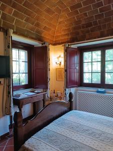 a bedroom with a bed and a desk and windows at Monte do Laranjal in Monsaraz +107 photos