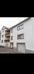 a white building with two garage doors in front of it at Bella Vita Apartment due in Ediger-Eller