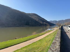 a road next to a river with a mountain at Bella Vita Apartment due in Ediger-Eller