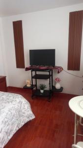 a bedroom with a bed and a table with a television at Habitación Privada Centro in Ayacucho