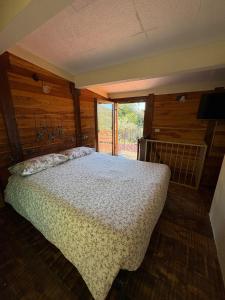 a bedroom with a bed and a large window at La Casetta di Molly tra ulivi e roseto in Leivi