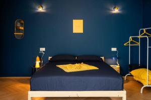 a blue bedroom with a bed with a yellow blanket on it at MR Suites Bergamo in Seriate