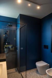 a bathroom with a toilet and a blue wall at MR Suites Bergamo in Seriate +7 photos