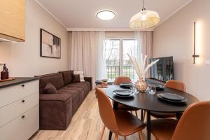 a living room with a table and a couch at Tarasy Bernardyńskie 44 in Kalisz