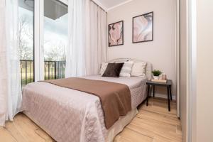 a bedroom with a bed and a balcony at Tarasy Bernardyńskie 44 in Kalisz