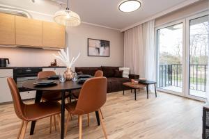 a kitchen and living room with a table and chairs at Tarasy Bernardyńskie 44 in Kalisz