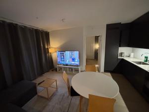 a living room with a white table and a kitchen at Apartment in Central Røa Oslo by the Train Station in Oslo