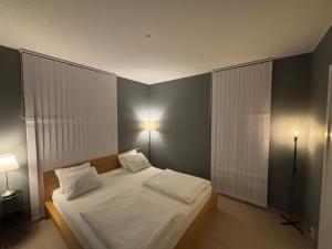 a bedroom with a bed with white sheets and pillows at Apartment in Central Røa Oslo by the Train Station in Oslo