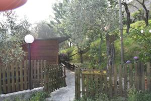 a wooden fence with a gate and a woodenshed at La Casetta di Molly tra ulivi e roseto in Leivi