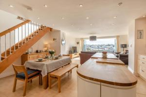 a living room with a staircase and a table and chairs at 3 Bed in Brixham oc-57892 in Brixham
