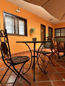 a table and chairs in a room with an orange wall at Posada El Remanso de Pueblo Nuevo in San Cristóbal